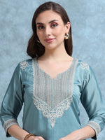 Load image into Gallery viewer, Woman wearing a light blue embroidered top against a gray background
