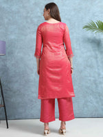 Load image into Gallery viewer, Woman wearing a pink kurta with pants against a blue wall.