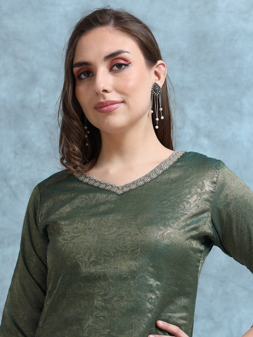 Woman wearing a green traditional outfit with silver detailing against a gray background