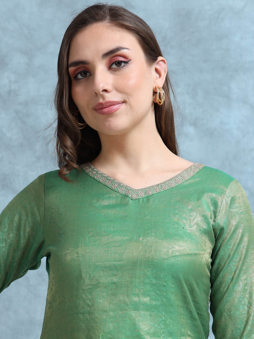 Woman wearing a green traditional outfit with a plain background