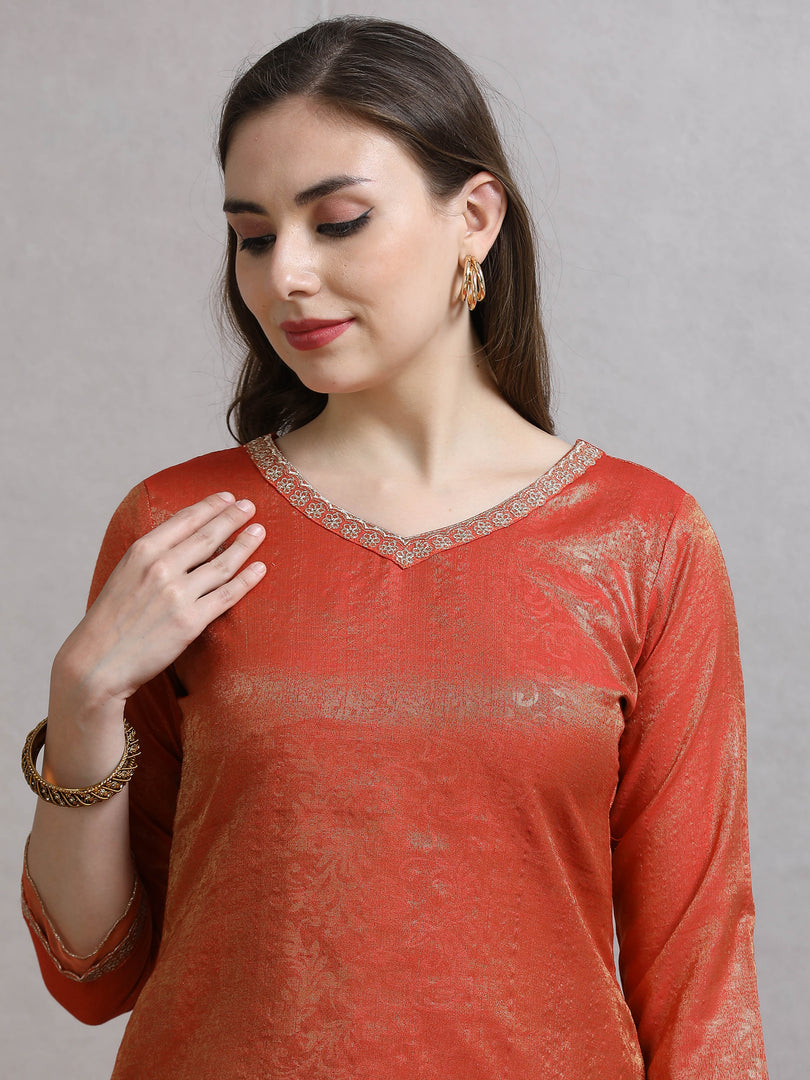 Woman wearing a red traditional outfit with intricate patterns on a gray background