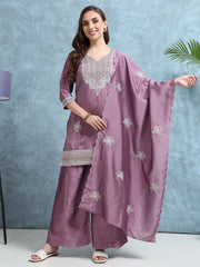 Woman wearing a mauve traditional outfit with silver embroidery against a light blue background