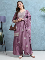 Load image into Gallery viewer, Woman wearing a mauve embroidered outfit with a matching dupatta against a blue background