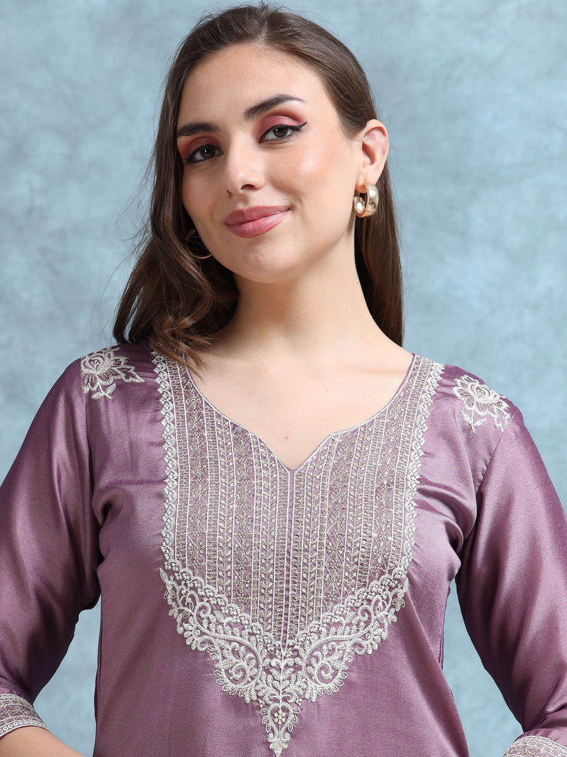 Woman wearing a purple top with white lace details against a light blue background