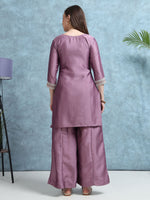 Load image into Gallery viewer, Woman wearing a mauve traditional outfit against a light blue wall.