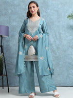 Load image into Gallery viewer, Woman wearing a light blue embroidered traditional outfit against a gray background